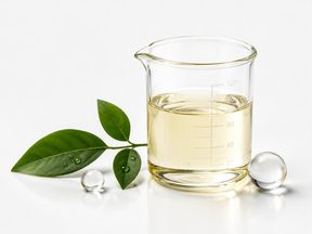 Pale yellow liquid in a glass beaker with foliage