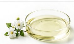 Pale liquid in a glass dish with blossom